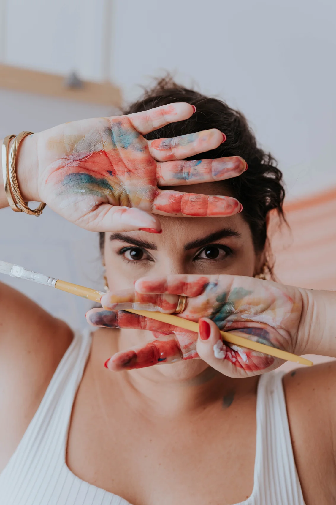 Andréa explorando cores e expressão com pintura nas mãos
